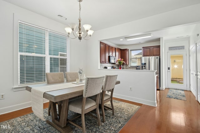 dining room featuring dark hardwood / wood-style floors and a chandelier