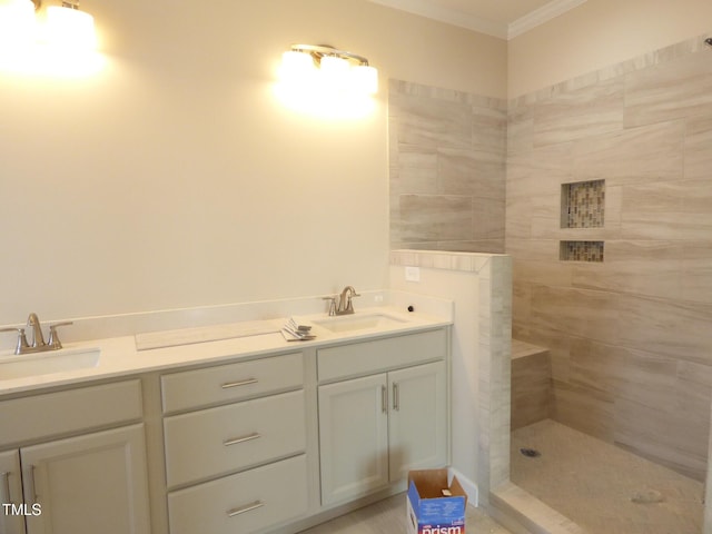 bathroom with crown molding, tiled shower, and vanity