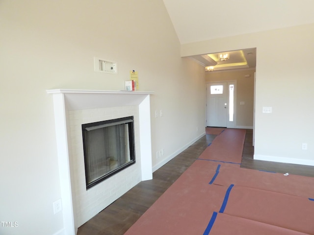 unfurnished living room featuring lofted ceiling, dark hardwood / wood-style floors, and a fireplace