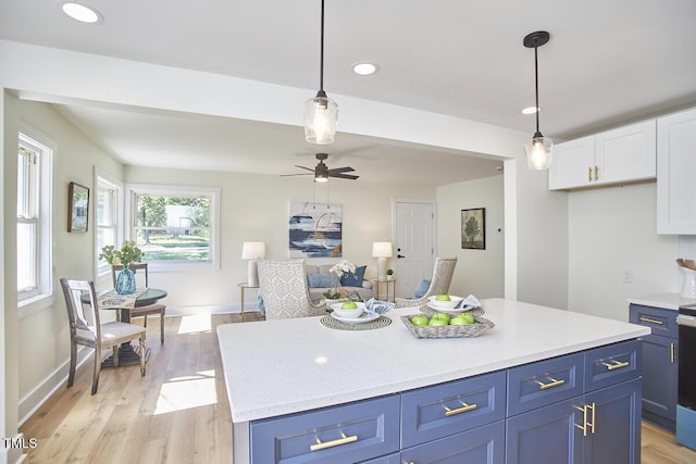 kitchen with blue cabinetry, white cabinetry, decorative light fixtures, and a kitchen island