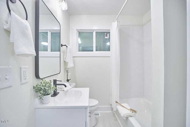 full bathroom with vanity, shower / tub combo, and toilet