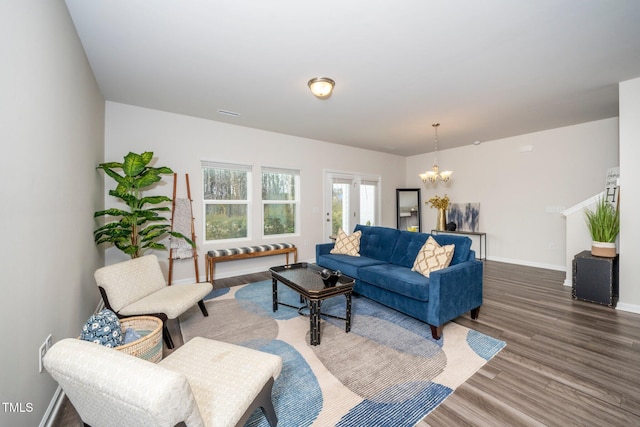 living room with dark wood-type flooring and a chandelier