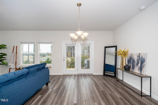 living room with hardwood / wood-style floors and a notable chandelier