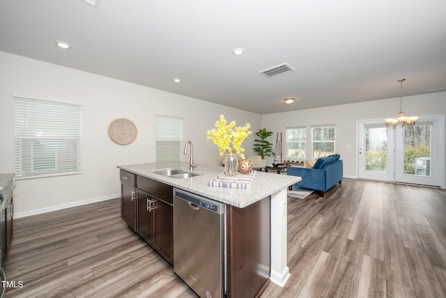 kitchen featuring dark brown cabinetry, sink, hanging light fixtures, a center island with sink, and dishwasher