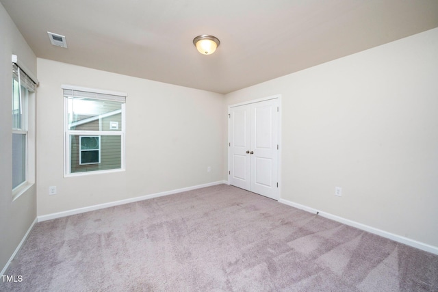 spare room featuring light colored carpet