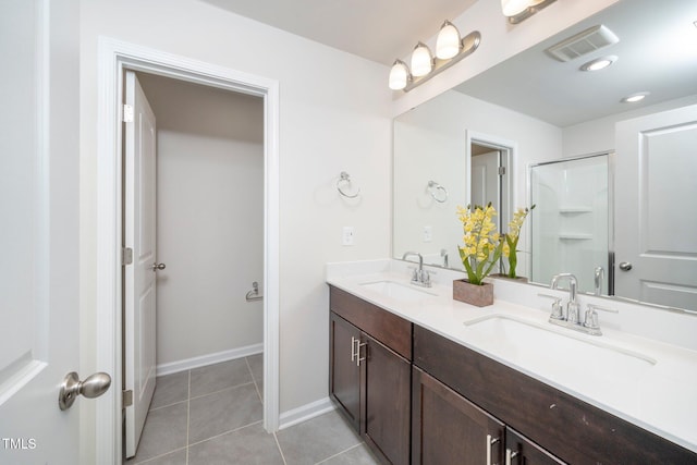 bathroom with tile patterned flooring, vanity, and a shower