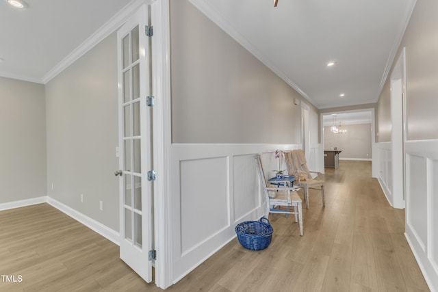 corridor with a chandelier, recessed lighting, wood finished floors, wainscoting, and crown molding