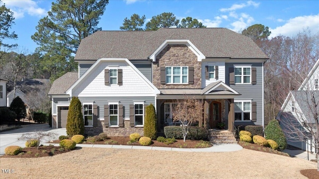 craftsman-style house with a garage, stone siding, a shingled roof, and concrete driveway