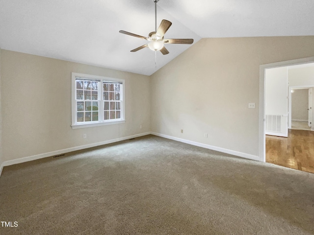 empty room with vaulted ceiling, carpet, and ceiling fan