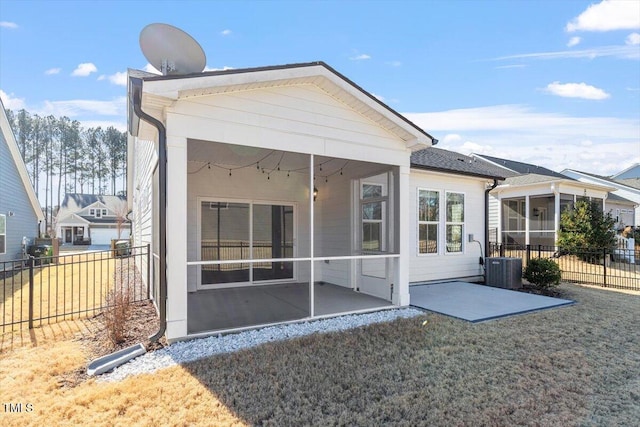 back of property with a yard, a patio area, a sunroom, and central AC