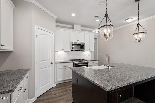 kitchen featuring stainless steel appliances, an island with sink, sink, and white cabinets