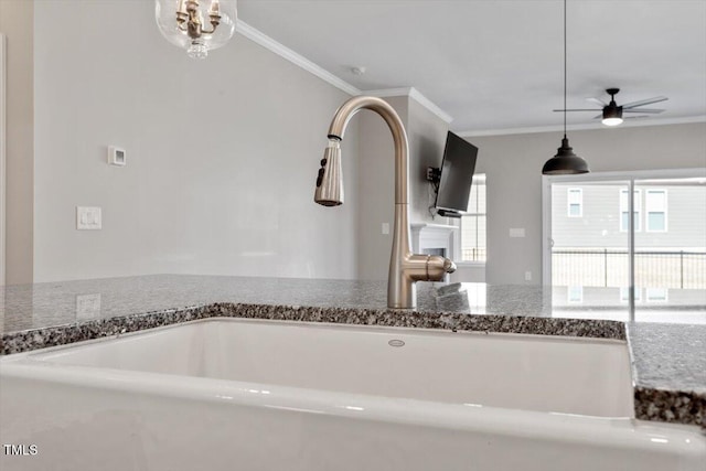 kitchen with crown molding, sink, stone countertops, and ceiling fan