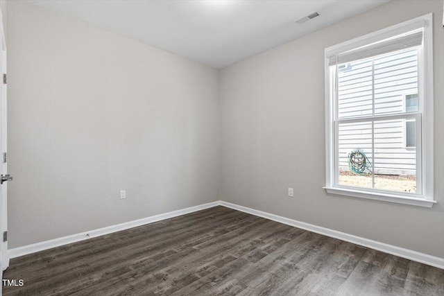 unfurnished room featuring dark wood-type flooring and plenty of natural light