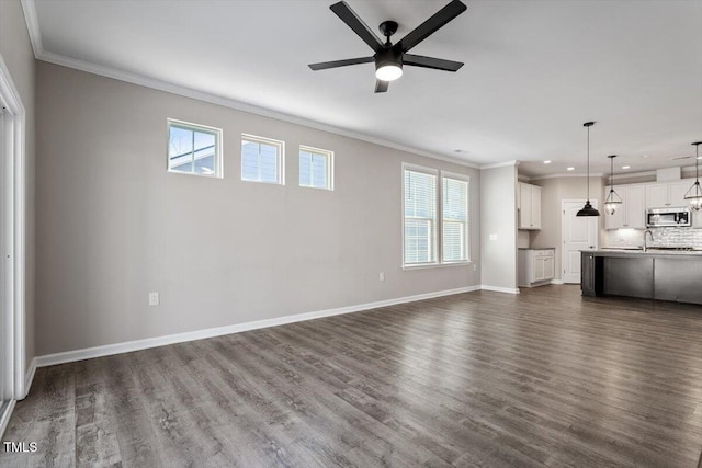 unfurnished living room with dark wood-type flooring, ornamental molding, and ceiling fan