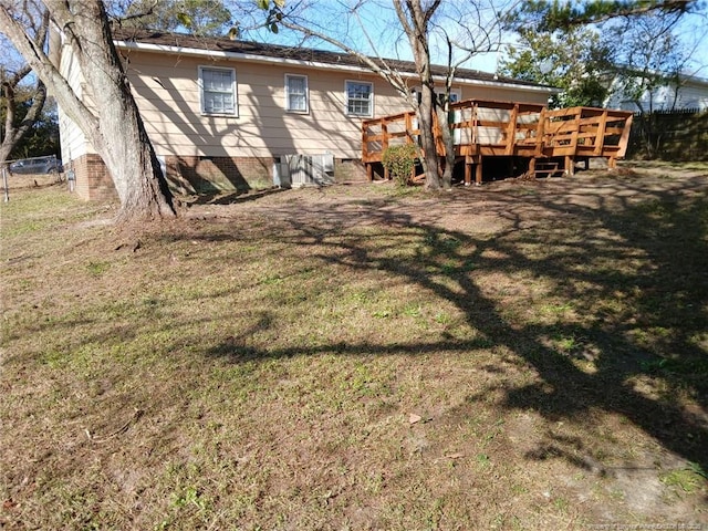 back of house featuring a deck and a lawn