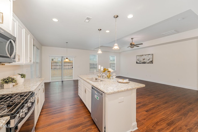 kitchen featuring sink, decorative light fixtures, an island with sink, stainless steel appliances, and white cabinets