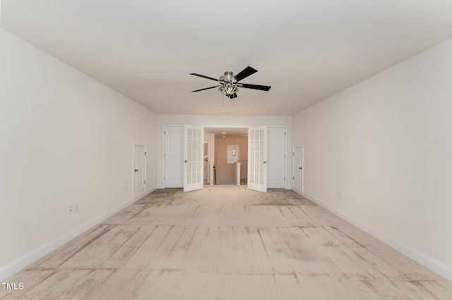 carpeted spare room featuring ceiling fan and french doors