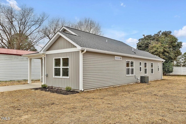 view of property exterior with cooling unit and a lawn