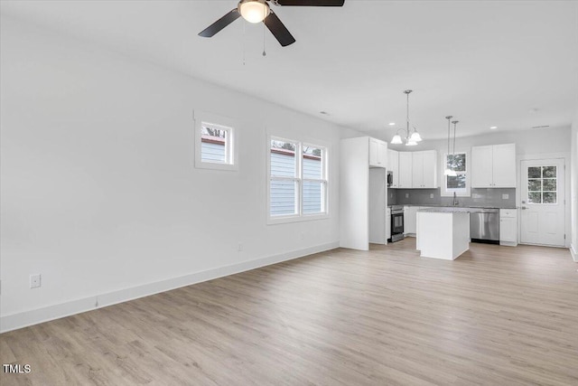 unfurnished living room featuring ceiling fan with notable chandelier, sink, and light hardwood / wood-style floors