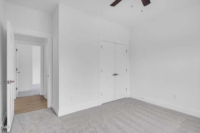 unfurnished bedroom with light carpet, ceiling fan, and a closet