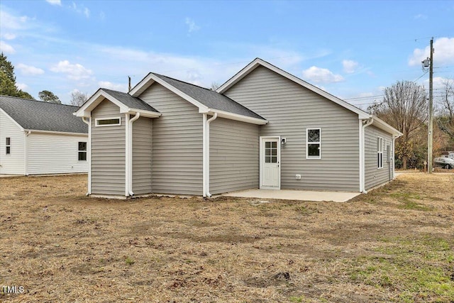 rear view of property with a lawn and a patio