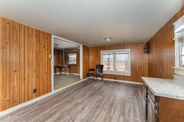 unfurnished room featuring light hardwood / wood-style floors and wood walls