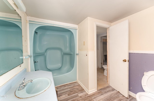 bathroom with sink, hardwood / wood-style floors, and toilet