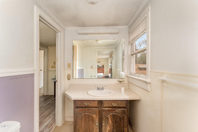 bathroom featuring vanity, ornamental molding, hardwood / wood-style floors, and toilet