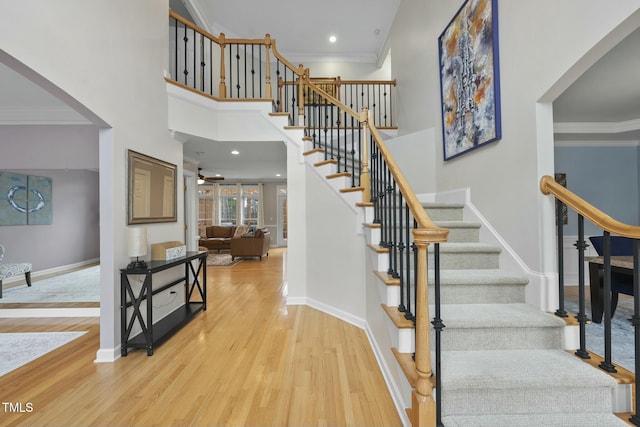 staircase with baseboards, ornamental molding, and wood finished floors