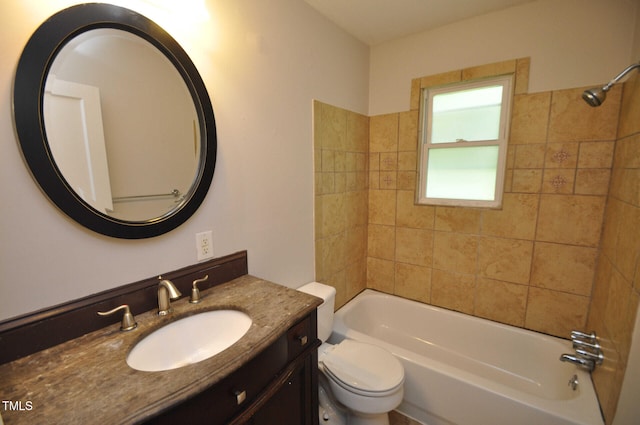 full bathroom featuring tiled shower / bath, vanity, and toilet