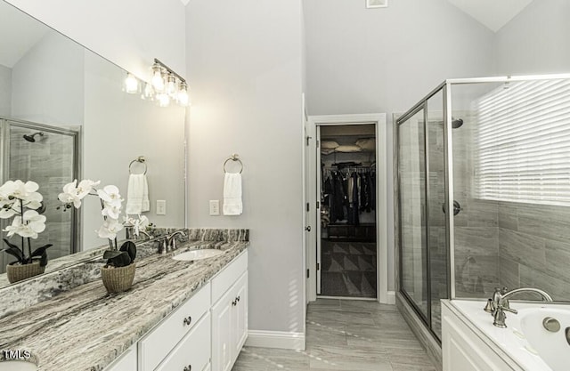 bathroom with vanity, lofted ceiling, and independent shower and bath