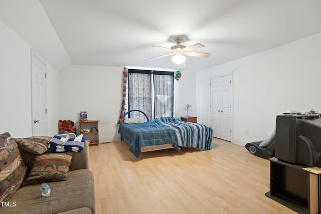 bedroom with ceiling fan, lofted ceiling, and light wood-type flooring