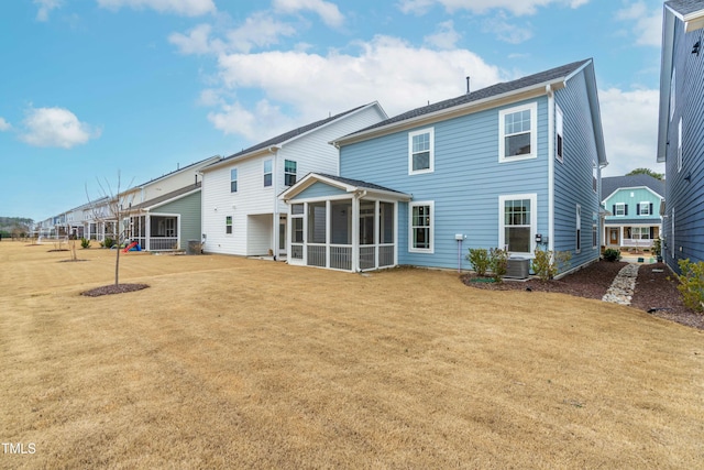 back of property with a sunroom and a yard