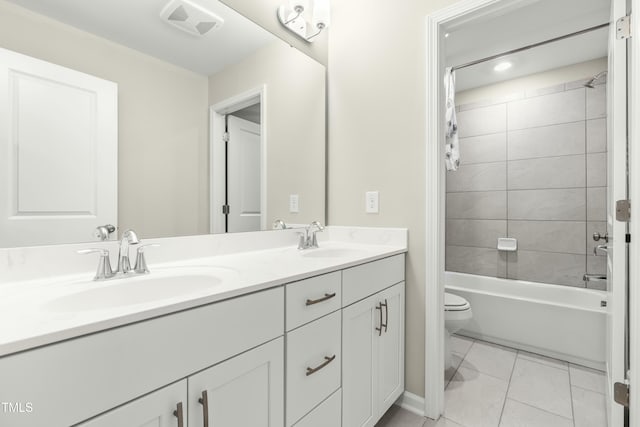 full bathroom featuring tiled shower / bath, vanity, and toilet