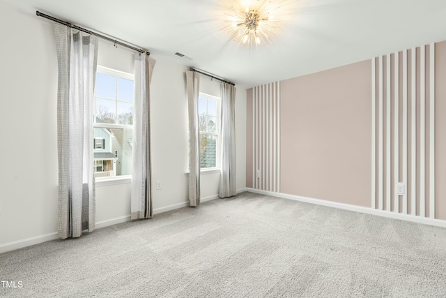 empty room featuring a chandelier and carpet