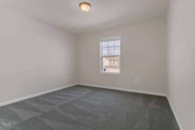 spare room featuring dark colored carpet