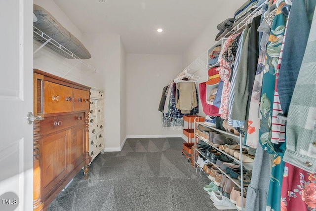 walk in closet featuring dark colored carpet