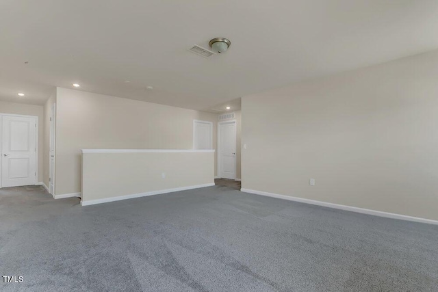 spare room featuring dark carpet