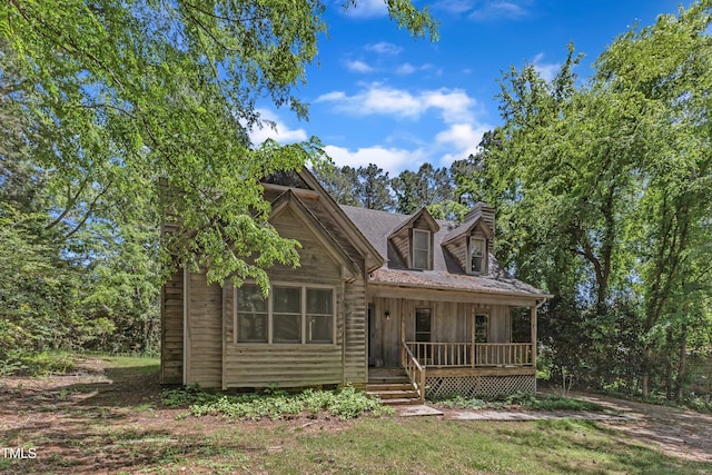 view of front of home with a porch, board and batten siding, and a chimney