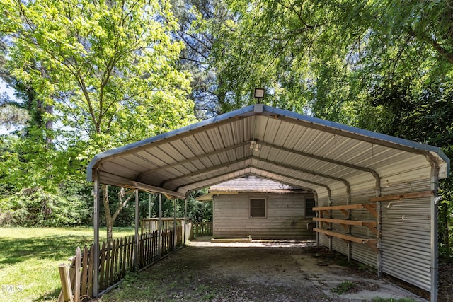 view of parking featuring fence and a detached carport