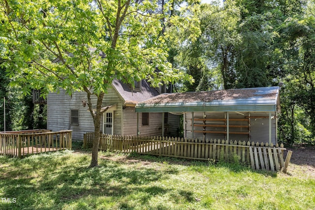 ranch-style house featuring a carport, fence private yard, and a front lawn