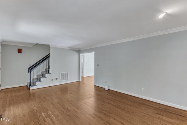 unfurnished living room with visible vents, ornamental molding, baseboards, and stairway