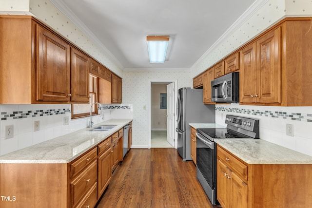 kitchen featuring a sink, crown molding, stainless steel appliances, and wallpapered walls