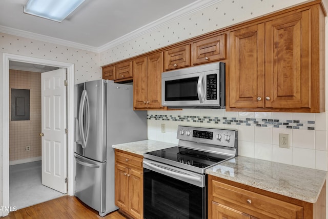 kitchen featuring crown molding, appliances with stainless steel finishes, and brown cabinetry