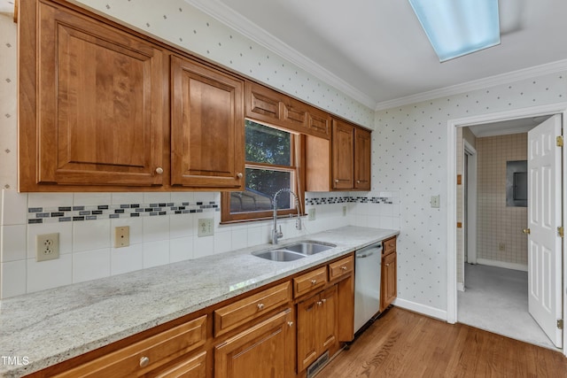 kitchen with brown cabinets, crown molding, a sink, light wood-style flooring, and stainless steel dishwasher