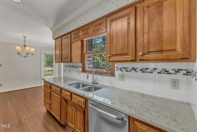 kitchen featuring a sink, crown molding, stainless steel dishwasher, and wallpapered walls
