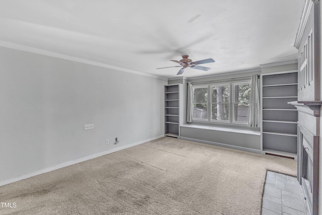 unfurnished living room with a ceiling fan, crown molding, a fireplace with flush hearth, carpet floors, and baseboards