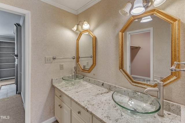 full bathroom featuring crown molding, a sink, a walk in closet, and double vanity