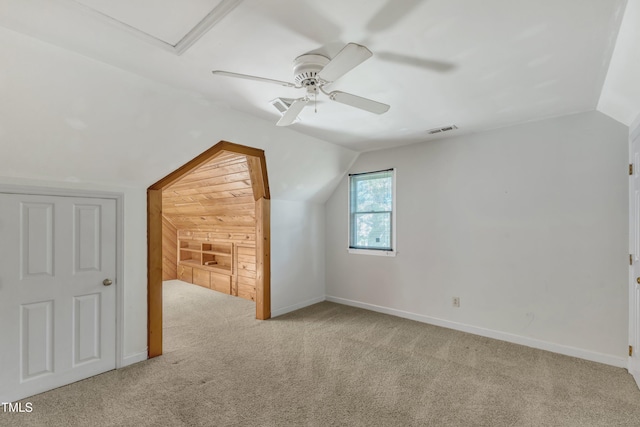 additional living space with ceiling fan, visible vents, vaulted ceiling, baseboards, and carpet