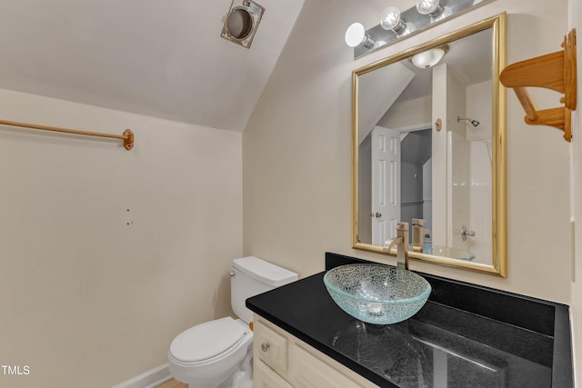 bathroom with vanity, vaulted ceiling, and toilet